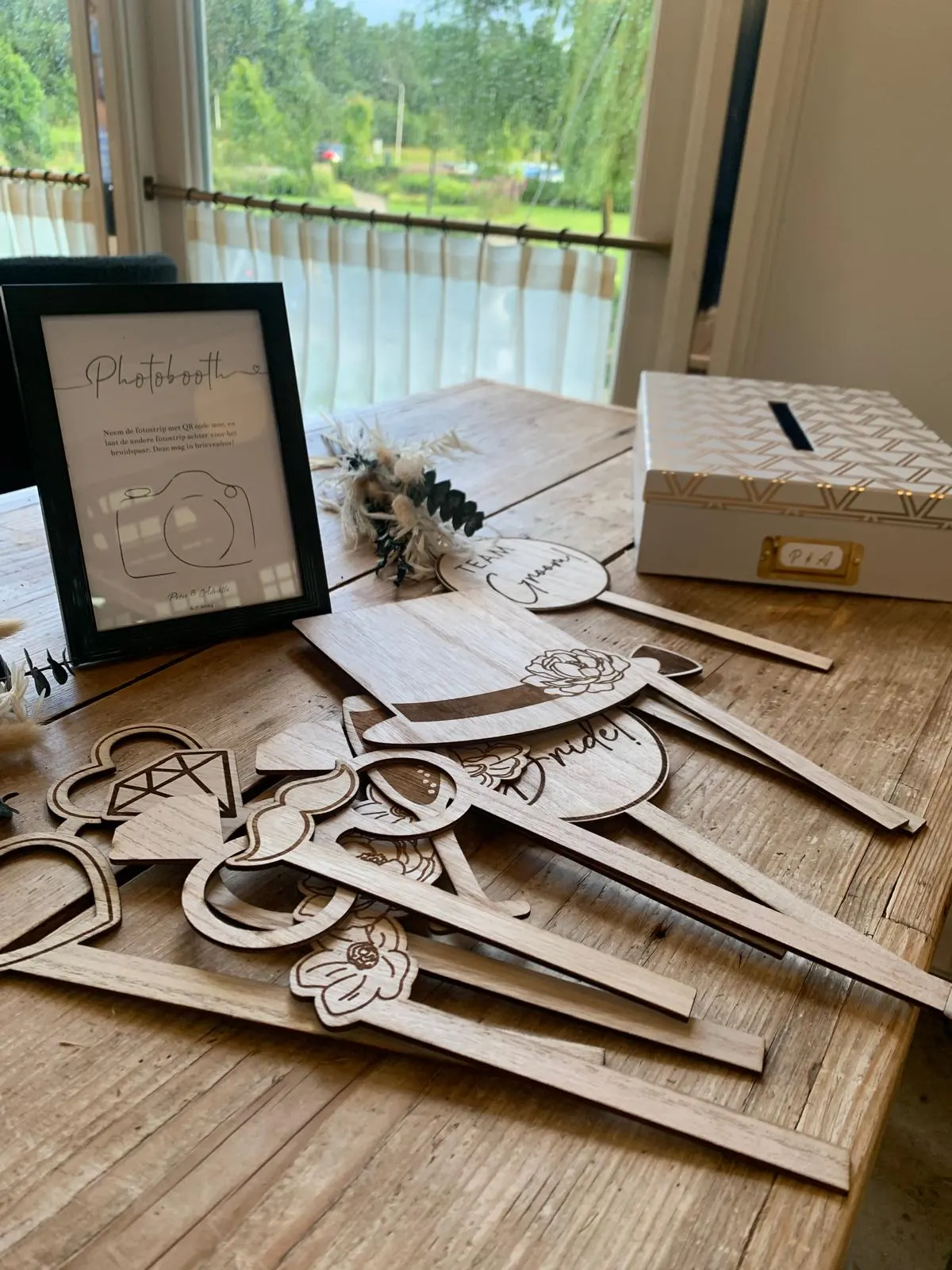 Houten photoboothprops en een gastenboek op een feesttafel