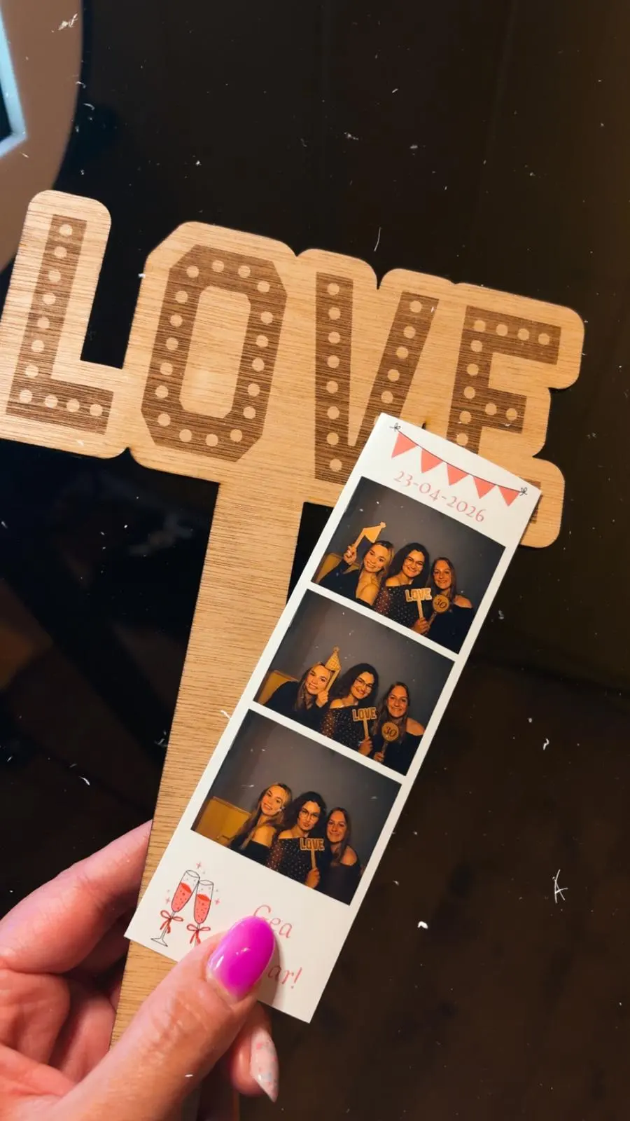 Een fotostrip in de hand voor verlichte LOVE-letters